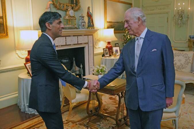 Le roi Charles III d'Angleterre et le Premier ministre britannique Rishi Sunak se font une poignée de main.