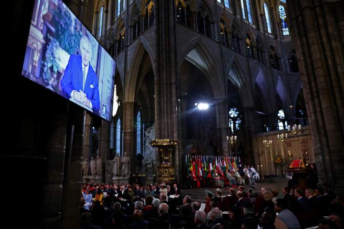 Les invités regardent une vidéo du roi Charles III délivrant un message lors de la cérémonie annuelle du Jour du Commonwealth à l'abbaye de Westminster à Londres.