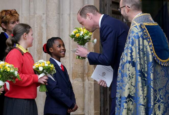 Le prince de Galles sent un bouquet de fleurs qu'on lui offre alors qu'il quitte le service annuel du Jour du Commonwealth à l'Abbaye de Westminster à Londres.