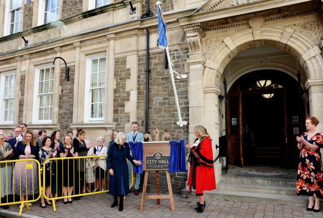 La reine Camilla dévoile une plaque commémorative à l'extérieur du conseil municipal de Douglas après avoir conféré le statut de ville à l'arrondissement de Douglas lors d'une visite sur l'île de Man.