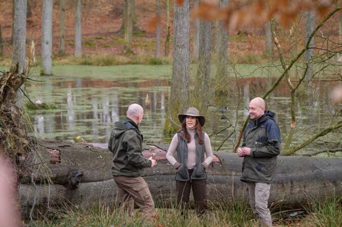 La reine Mary du Danemark discute avec des gardiens forestiers près d'un étang