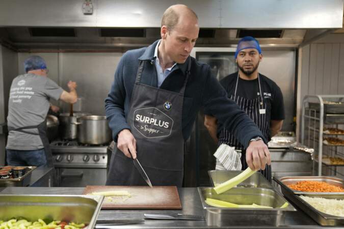 Le prince de Galles coupe du céleri tout en aidant à préparer une sauce bolognaise.