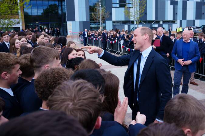 Le Prince serre la main des élèves à l'extérieur de l'école
