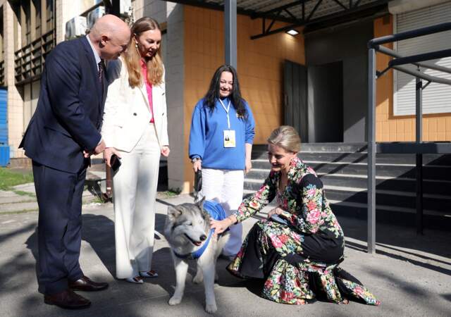 La duchesse d'Édimbourg caresse un chien au bureau du Fonds des Nations Unies pour la population à Kiev.